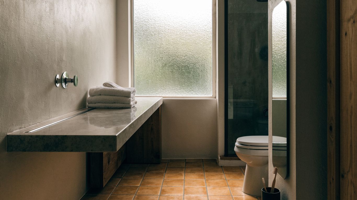 Warm tiled bathroom floor beside modern vanity